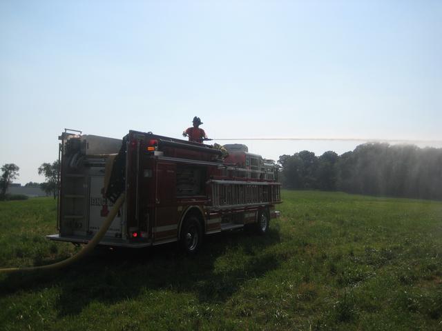 Firefighter Luke Harshbarger mans the deck pipe at hay bale fire in Lower Oxford Township.